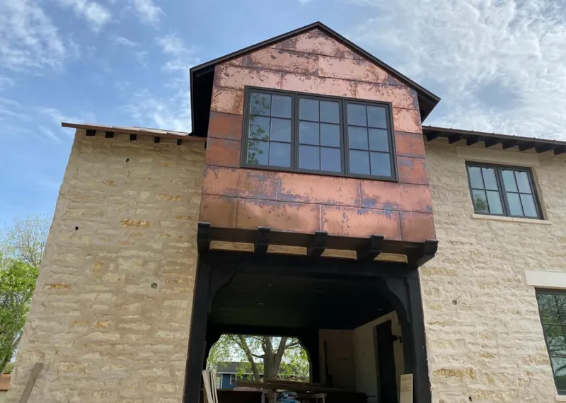 Copper metal panel facade on a stone building for Roof Repair in Westland